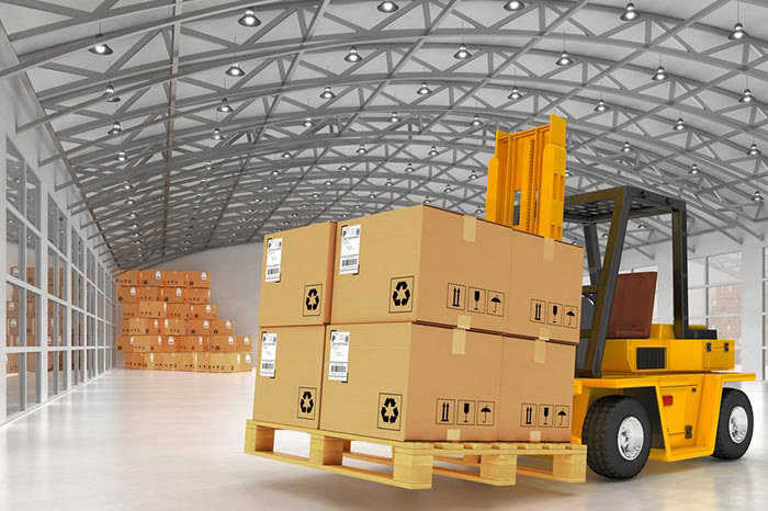 Forklift handling palletized cartons inside warehouse